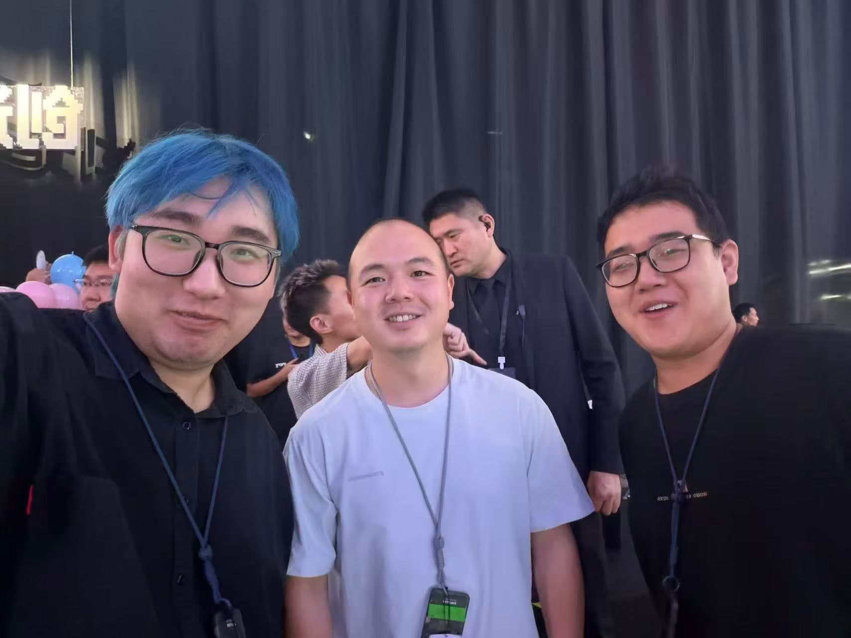 TRAE 大赛现场，三位朋友站在一起微笑合影